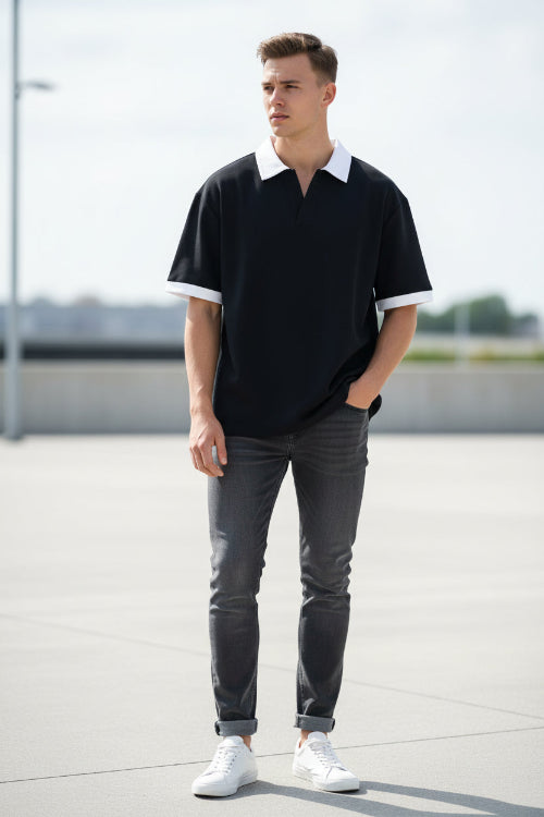 Person wearing a black t-shirt with white trim on a white background