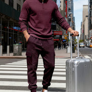 A man wearing a matching burgundy waffle-knit quarter-zip pullover and jogger pants 