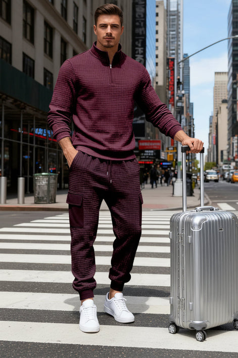 A man wearing a matching burgundy waffle-knit quarter-zip pullover and jogger pants 
