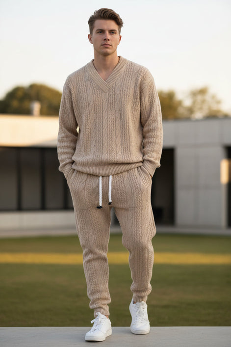 A person modeling a matching beige cable-knit sweater and jogger pants set with white drawstrings, 