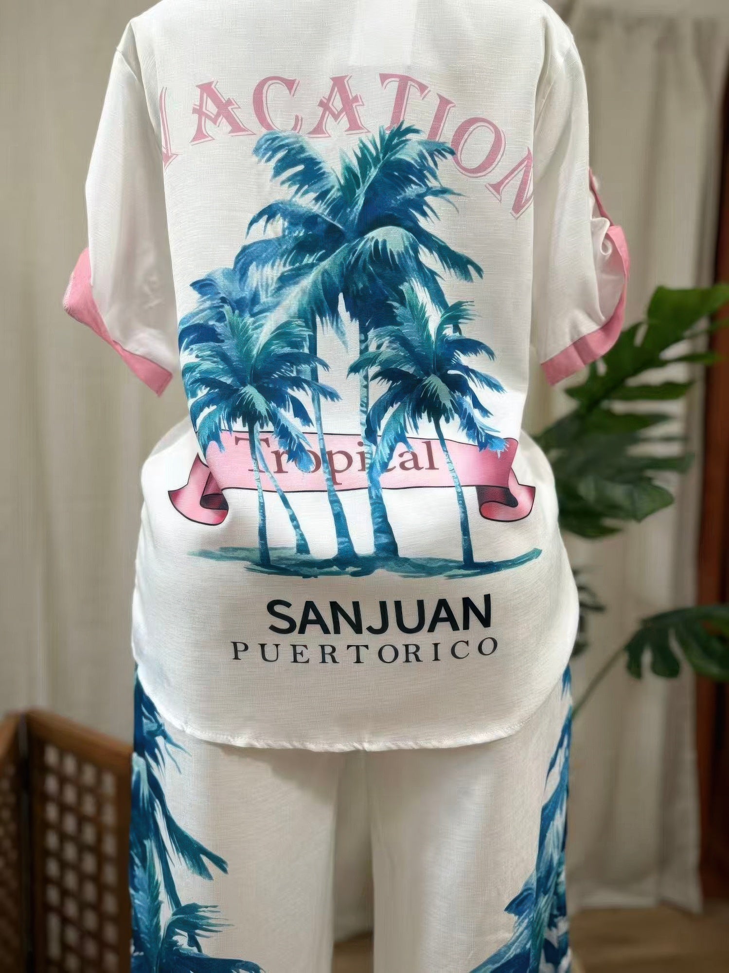White outfit with tropical palm tree design and 'Sanjuan Puerto Rico' text on a plain background