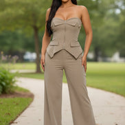 Woman wearing a beige strapless jumpsuit on a white background
