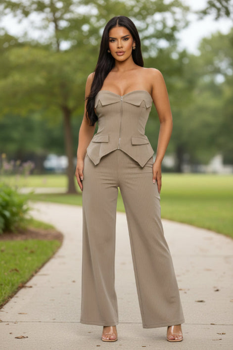 Woman wearing a beige strapless jumpsuit on a white background