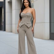 Woman wearing a beige strapless jumpsuit on a white background