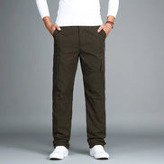 Army green cargo pants with cargo pockets worn by a man with white sneakers, shown from the front