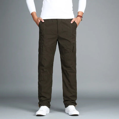 Army green cargo pants with cargo pockets worn by a man with white sneakers, shown from the front