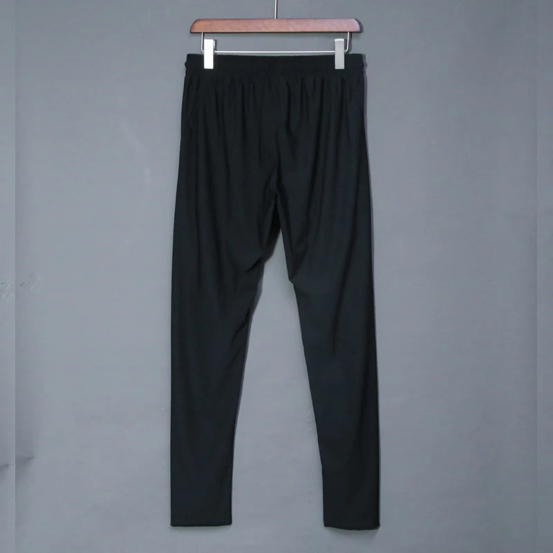 Black pants hanging on a gray background