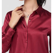 Close-up of a red silk shirt's collar and button front.