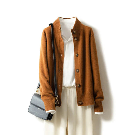 Brown cardigan over a white shirt with beige pants and a black handbag on a white background