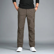 Camel cargo pants with cargo pockets worn by a man with white sneakers, shown from the front