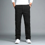Black cargo pants with cargo pockets worn by a man with white sneakers, shown from the front