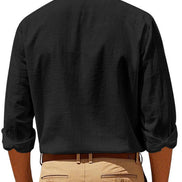 Back view of men's black linen blend stand collar shirt with rolled sleeves, tucked into khaki trousers with a brown belt