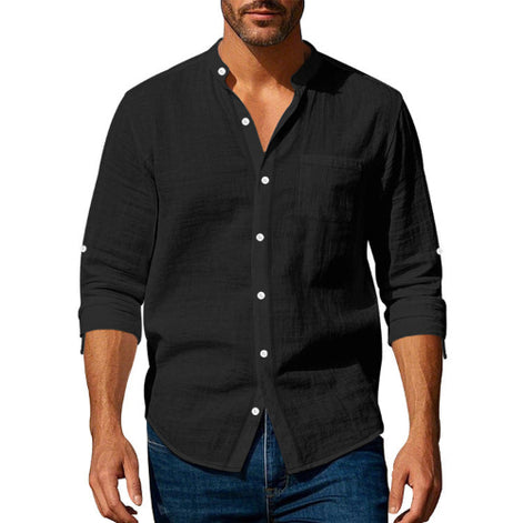 Men's black linen blend stand collar shirt with a button front, chest pocket, and rolled sleeves, worn with dark blue jeans