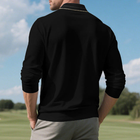 Back view of men's black long sleeve polo shirt with fine contrasting collar stripes, modeled outdoors with sleeves pushed up and gray trousers