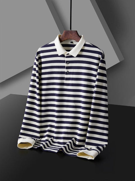 Men's navy blue and white striped long sleeve polo shirt shown from the front with a white collar, three-button placket, and white cuffs on a wooden hanger