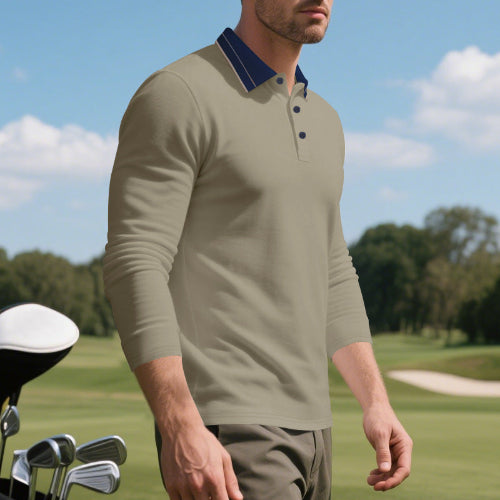 Angled front view of men's taupe long sleeve polo shirt with a contrasting navy collar and three-button placket, modeled beside golf clubs on a golf course
