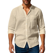 Men's khaki linen blend stand collar shirt with a button front, chest pocket, and rolled sleeves, worn with dark blue jeans