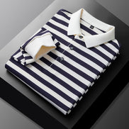 Men's navy blue and white striped long sleeve polo shirt folded to show the white collar, three-button placket, and white cuff