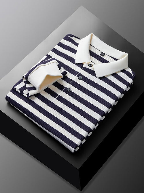 Men's navy blue and white striped long sleeve polo shirt folded to show the white collar, three-button placket, and white cuff
