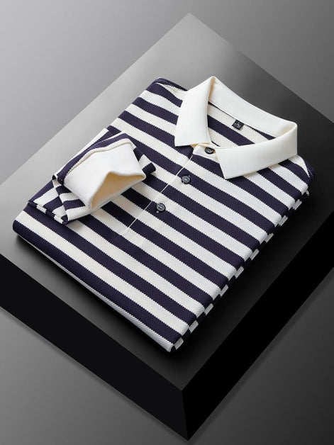 Men's navy blue and white striped long sleeve polo shirt folded to show the white collar, three-button placket, and white cuff