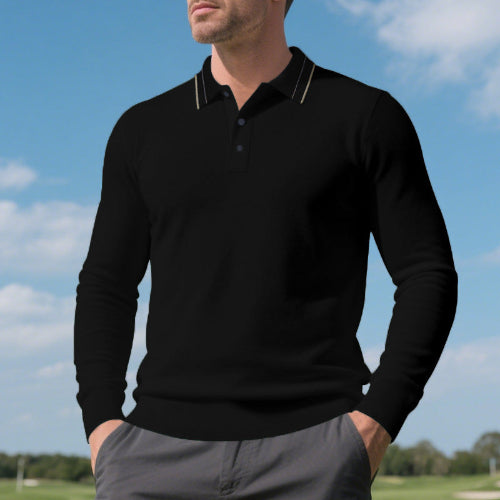 Men's black long sleeve polo shirt with fine contrasting collar stripes and a button placket, modeled outdoors with gray trousers
