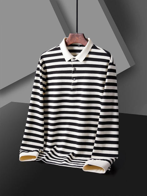 Men's black and white striped long sleeve polo shirt shown from the front with a white collar, three-button placket, and white cuffs on a wooden hanger