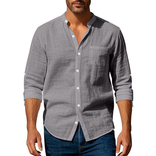 Men's gray linen blend stand collar shirt with a button front, chest pocket, and rolled sleeves, worn with dark blue jeans