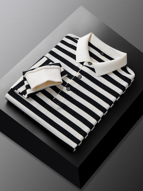 Men's black and white striped long sleeve polo shirt folded to show the white collar, three-button placket, and white cuff