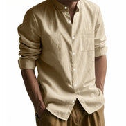 Men's khaki linen blend stand collar shirt with a button front, chest pocket, and rolled tab sleeves, worn with brown trousers