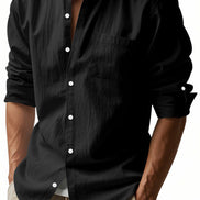 Men's black linen blend stand collar shirt with a button front, chest pocket, and rolled tab sleeves, worn with khaki trousers