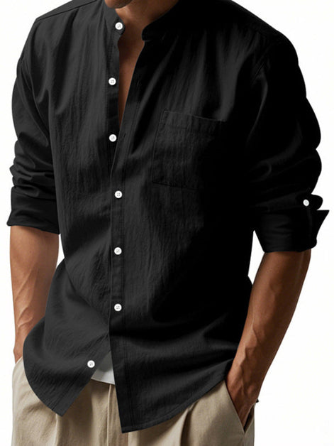 Men's black linen blend stand collar shirt with a button front, chest pocket, and rolled tab sleeves, worn with khaki trousers
