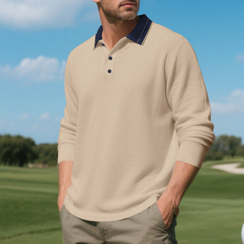 Men's khaki long sleeve polo shirt with a contrasting dark collar and three-button placket, modeled outdoors with sleeves pushed up and taupe trousers