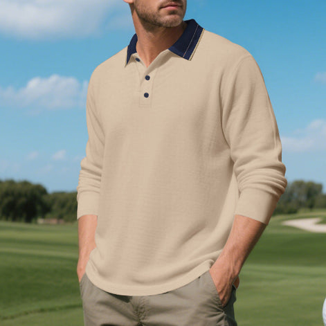 Men's khaki long sleeve polo shirt with a contrasting dark collar and three-button placket, modeled outdoors with sleeves pushed up and taupe trousers