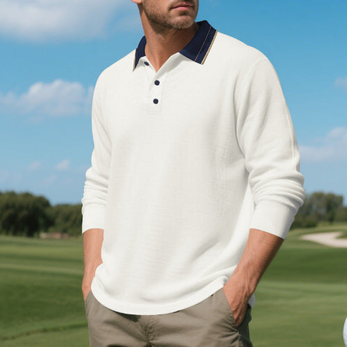 Men's white long sleeve polo shirt with a contrasting navy collar and three-button placket, modeled outdoors with sleeves pushed up and taupe trousers