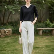 Mannequin wearing a black V-neck sweater with a neutral background