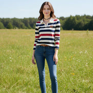 A woman wearing a long-sleeve collared knit top with horizontal stripes in cream, navy blue, black, and red. The top has a small brown patch on the left chest.