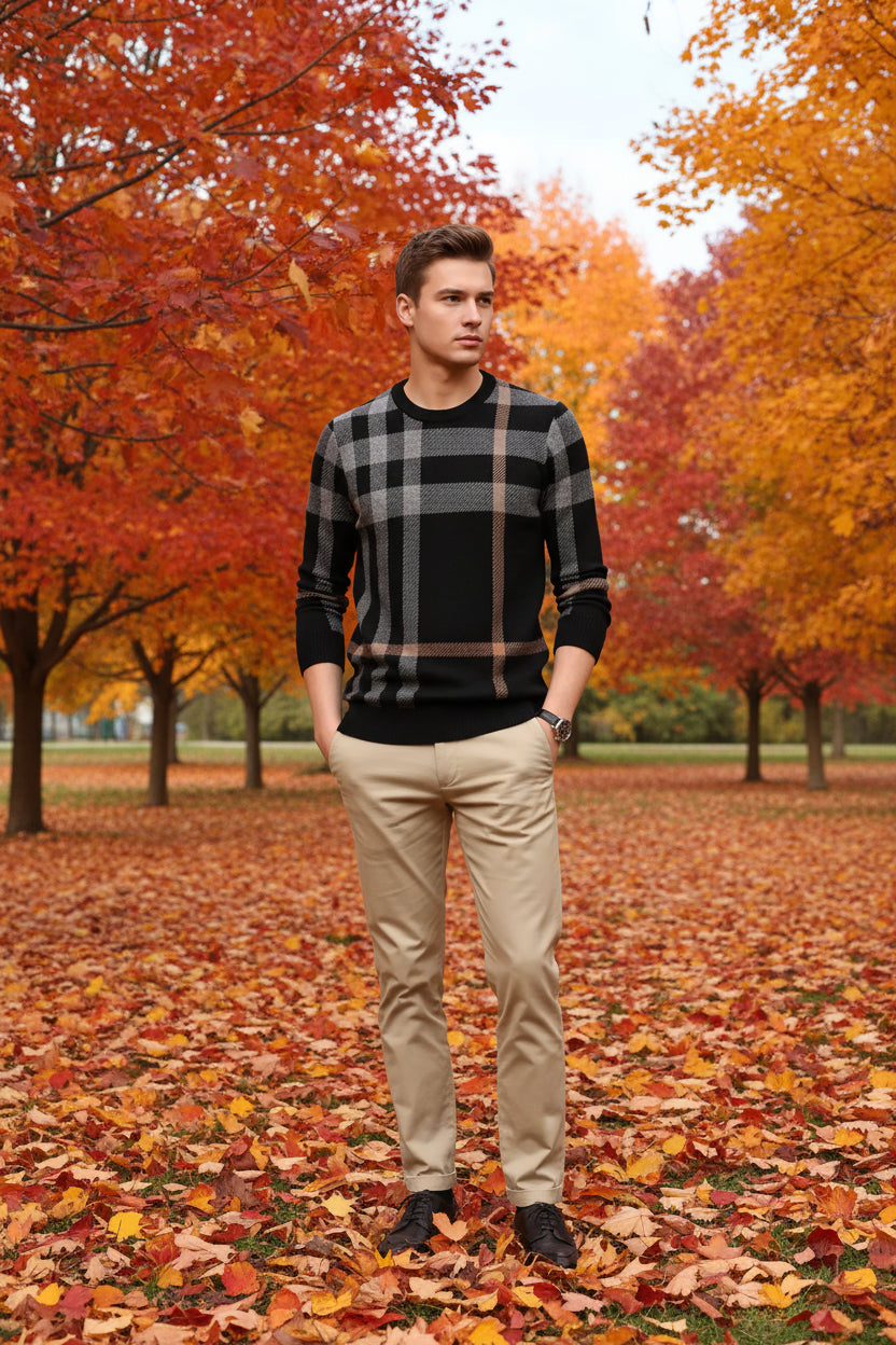 Black and beige plaid sweater worn by a person on a gray background