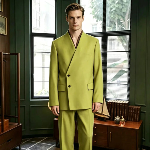 A man wearing a bright yellow-green two-piece suit with a wrap-style double-breasted jacket and matching trousers, standing in a dark green room with large windows and wooden furniture.