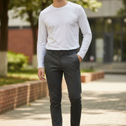 Person wearing dark gray pants and brown shoes on a gray background