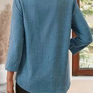 Person wearing a blue textured shirt in an indoor setting