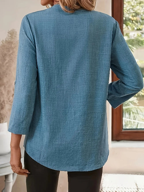 Person wearing a blue textured shirt in an indoor setting