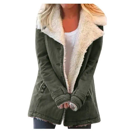 Woman wearing an olive green coat with wide cream fleece-look lapels, front pockets and cuff tabs over a white top and dark trousers