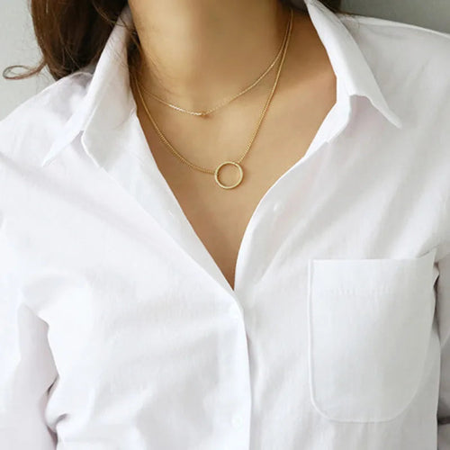 Close-up of the collar and chest pocket of a white button-down shirt.