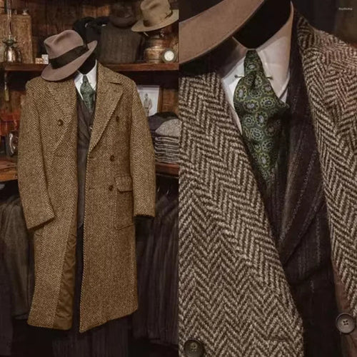 A vintage-style men's suit ensemble displayed on a mannequin in a shop setting, featuring a brown herringbone double-breasted overcoat, a dark patterned vest, 