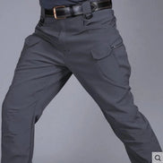 Front view of a model wearing dark gray cargo pants with flap thigh pockets and a black belt against a gray background.