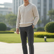 Folded white sweater in a black box with a watch on a dark surface