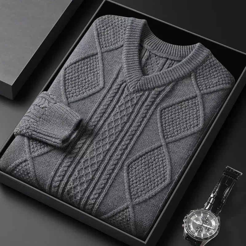 Gray patterned sweater in a black box with a watch on a dark surface