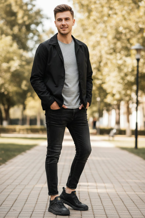 Black sneakers worn with black jeans on a beige background