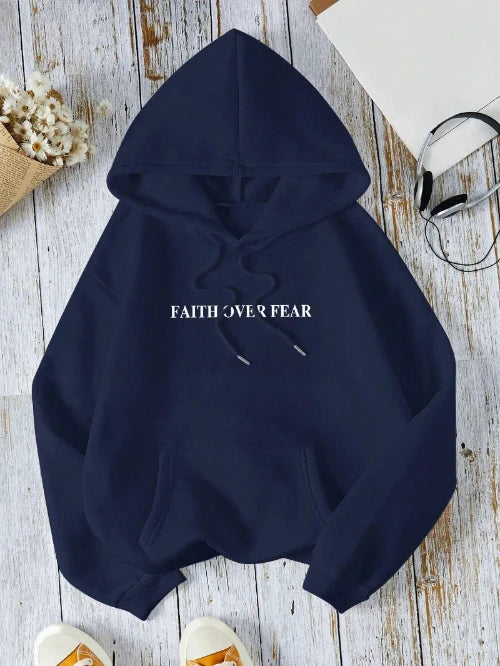 Navy blue hoodie with 'FAITH OVER FEAR' text on a wooden surface.