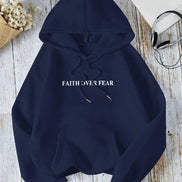 Navy blue hoodie with 'FAITH OVER FEAR' text on a wooden surface.